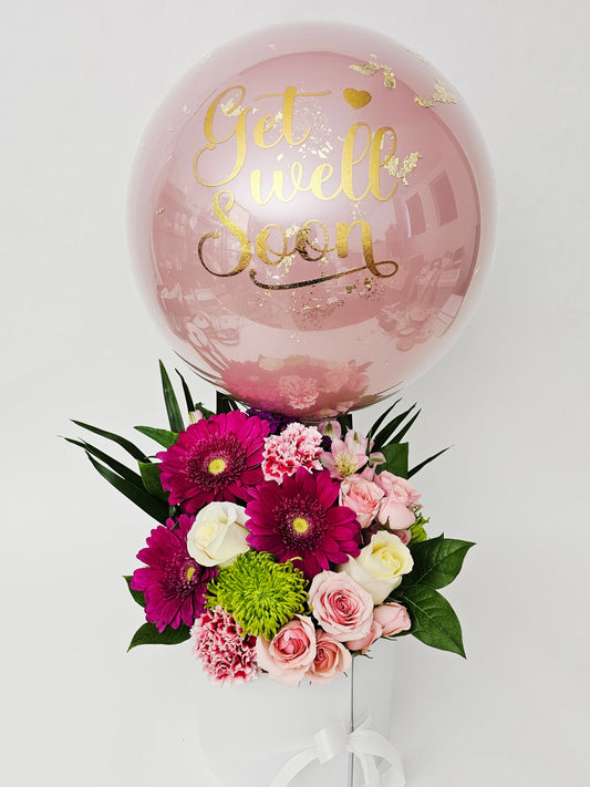 Bouquet of flowers and a balloon with gold text on a white background