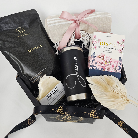 luxury gift box features a premium insulated stainless steel travel tumbler permanently laser-engraved for a sophisticated, personal touch. Paired with artisanal organic self-care essentials and gourmet loose-leaf tea, it offers the ultimate moment of calm and indulgence.
