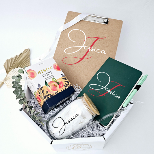 This premium gift package combines everyday functionality with personalized flair, making it the ideal present for any professional. Inside you'll find: a sleek can-shaped drinking glass with a natural bamboo lid and glass straw for refreshing beverages, a personalized notebook to capture your brilliant ideas, a personalized clipboard to keep your tasks organized, and a box of gourmet tea for moments of mindful calm. Give the gift of elevated essentials!