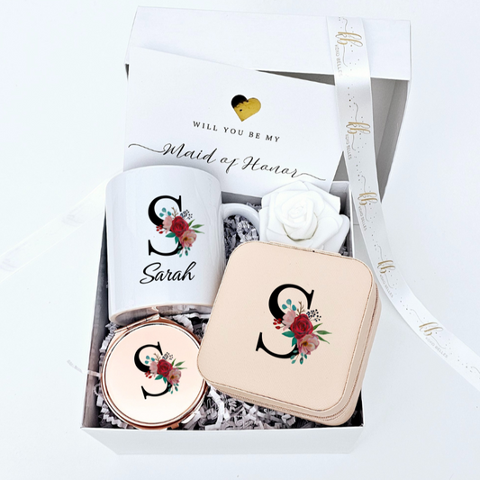 Make your bridesmaid proposal special with personalized floral keepsakes! This set includes a custom mug, jewelry case, mirror with floral initials, a rose, and a heartfelt card.