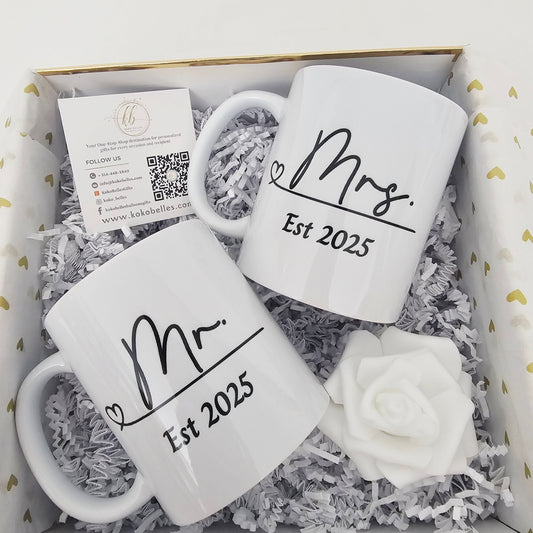 Two white mugs with 'Mr.' and 'Mrs.' text in a white with gold trim box