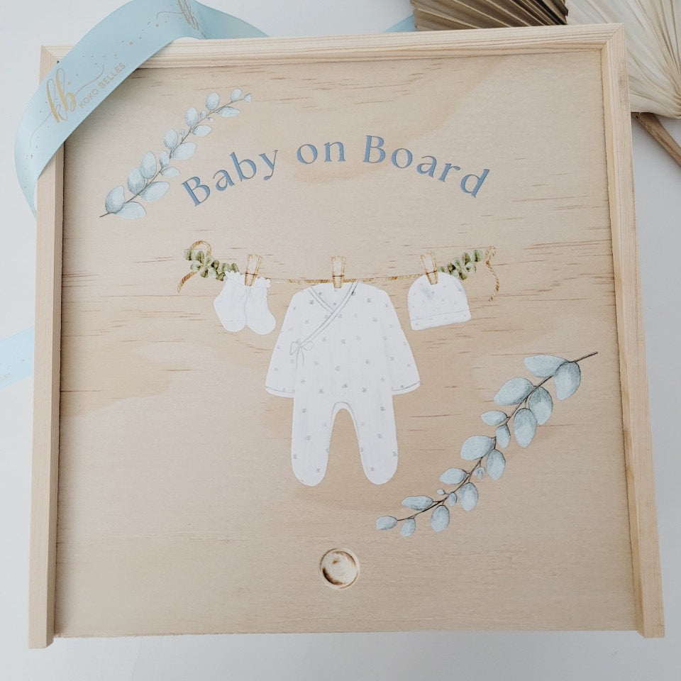 Custom wooden birth announcement box for newborns featuring a watercolor clothesline with a onesie and booties.