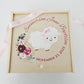 Decorative box with a lamb illustration and floral elements on a white background