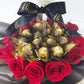Custom birthday bubble balloon gift box with red roses, Ferrero Rocher chocolates, and gold and silver balloon arrangement.