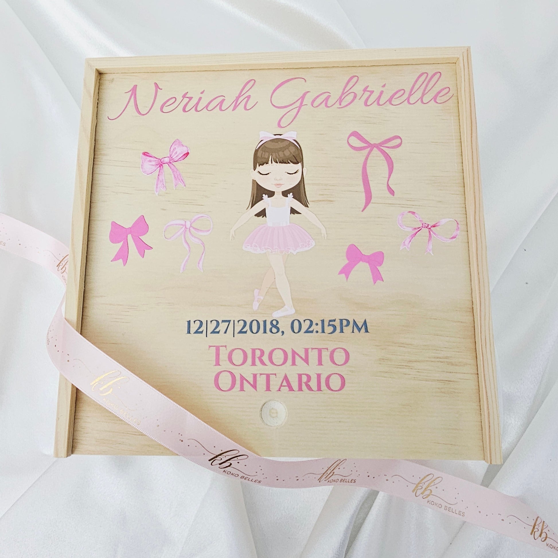 Personalized wooden baby girl birth announcement box featuring a watercolor ballerina dancer and soft pink bows with custom name and birth details.