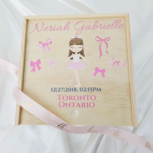 Personalized wooden baby girl birth announcement box featuring a watercolor ballerina dancer and soft pink bows with custom name and birth details.