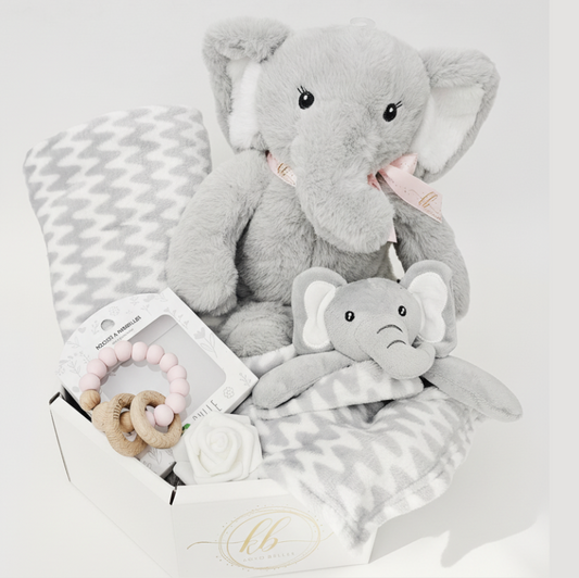 Baby gift set with plush elephant toys and a blanket on a light gray background