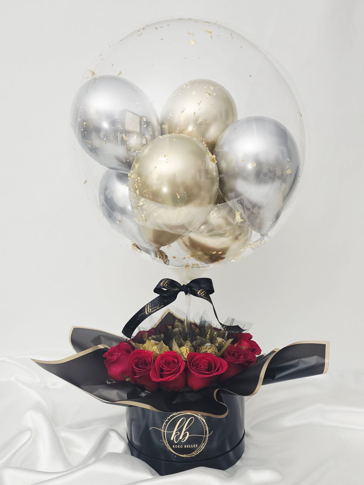 Boîte-cadeau personnalisée avec ballon bulle transparent "Older Hotter Better", mini-ballons or et argent, roses rouges et chocolats Ferrero Rocher.