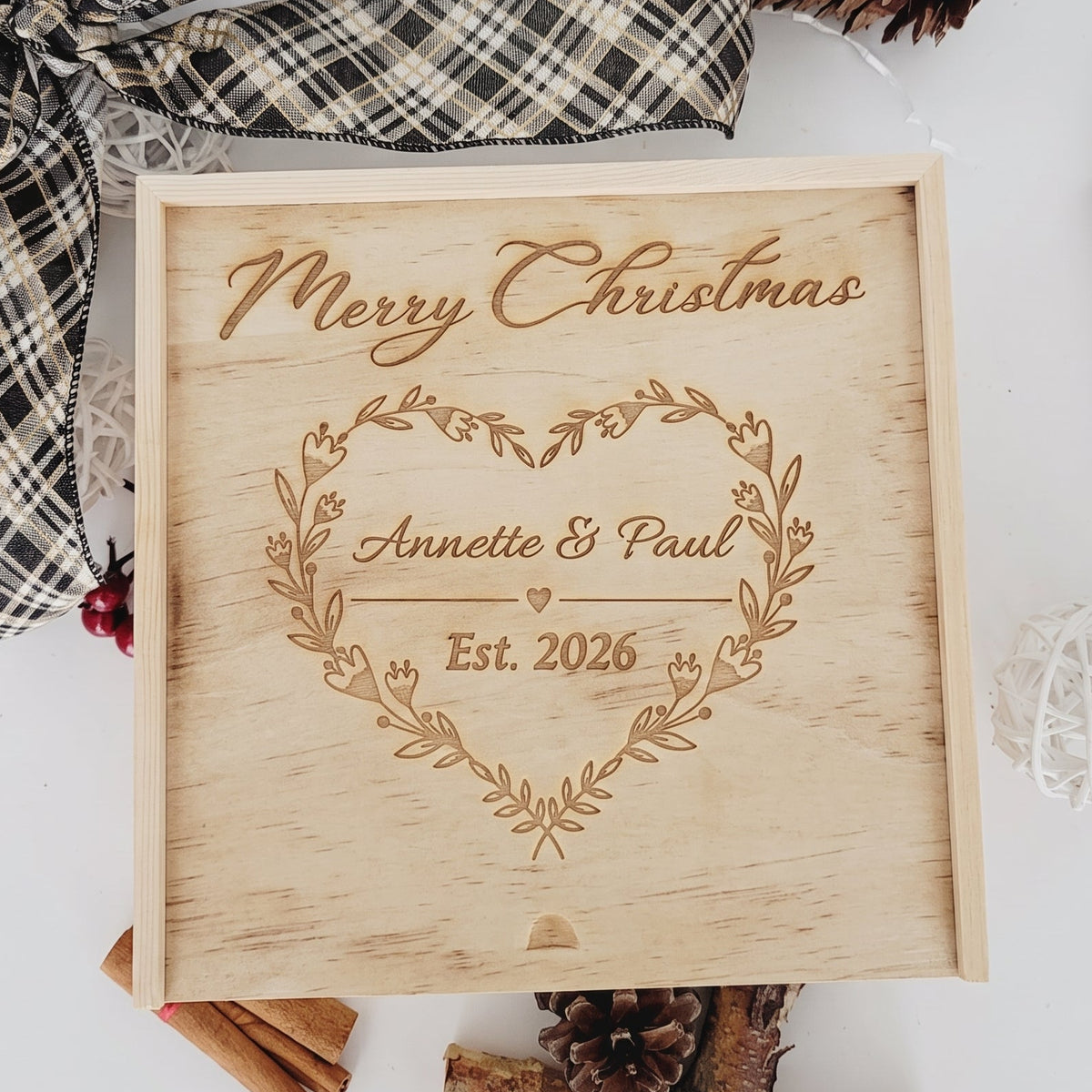 Personalized wooden holiday keepsake box engraved with a floral heart wreath, couples names, and established year.