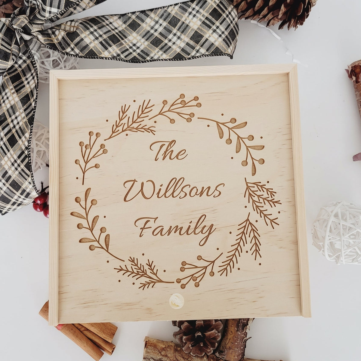 Personalized wooden holiday keepsake box with laser-engraved Christmas wreath and custom family last name.