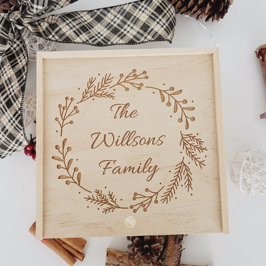 Personalized wooden holiday keepsake box with laser-engraved Christmas wreath and custom family last name.