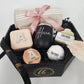 A beautifully curated spa gift box featuring custom name drinkware, personalized travel accessories, and artisanal bath products by Koko Belles.