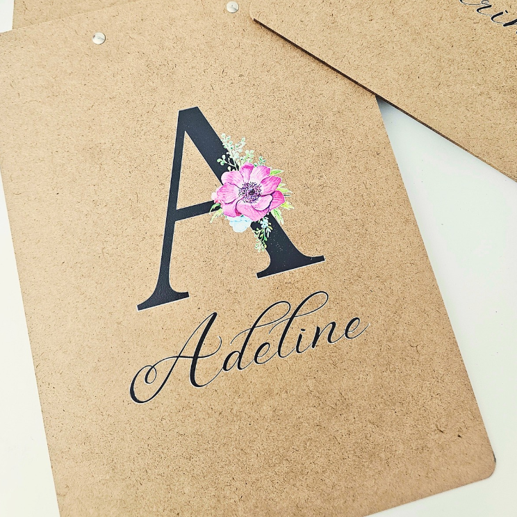 Personalized wooden clipboard resting on an organized desk next to office supplies.
