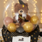 Teddy bear in a stuffed balloon with mini balloons and a 'Congratulations' card on a festive background.
