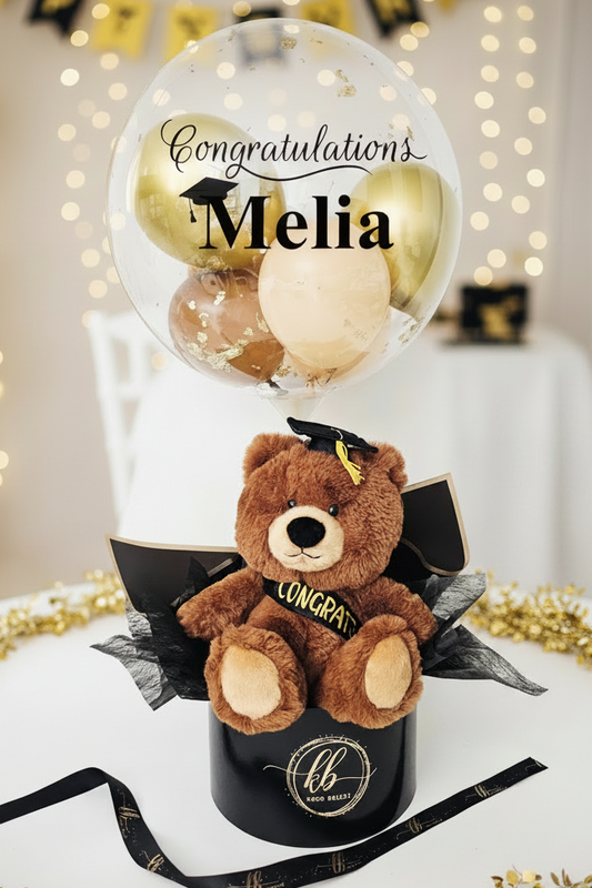 Graduation-themed gift with teddy bear, balloon, and 'Congratulations Melia' text 