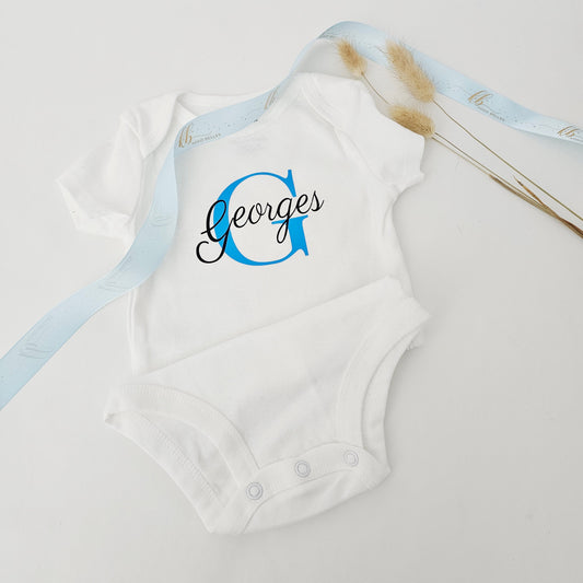 Custom baby boy onesie with bold blue initial G and black script name Georges.