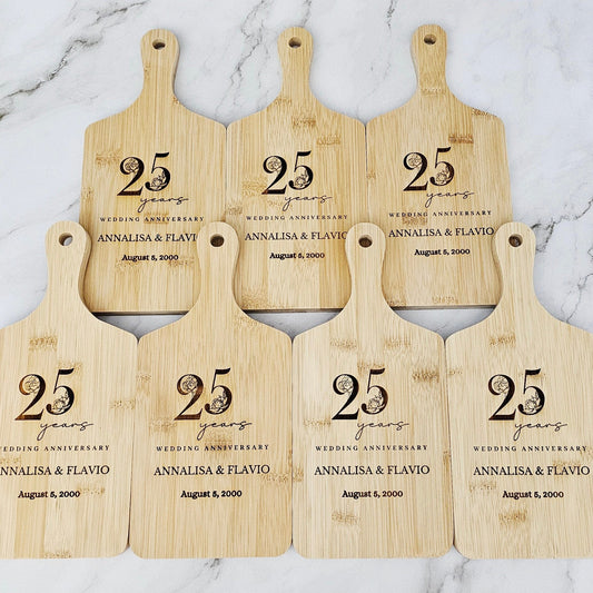 Set of six wooden cutting boards with '25 years' anniversary text on a marble background