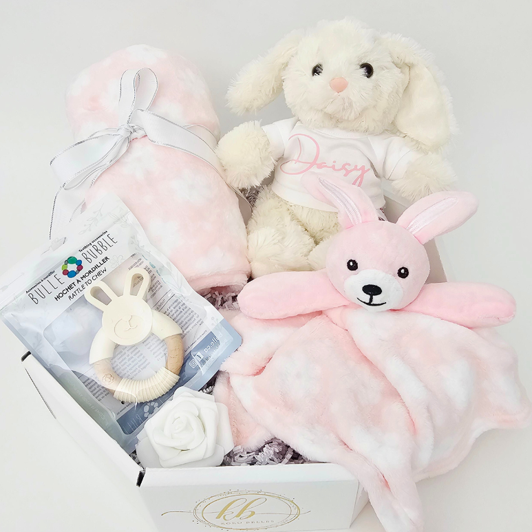 Baby gift set with plush toys and a blanket on a white background