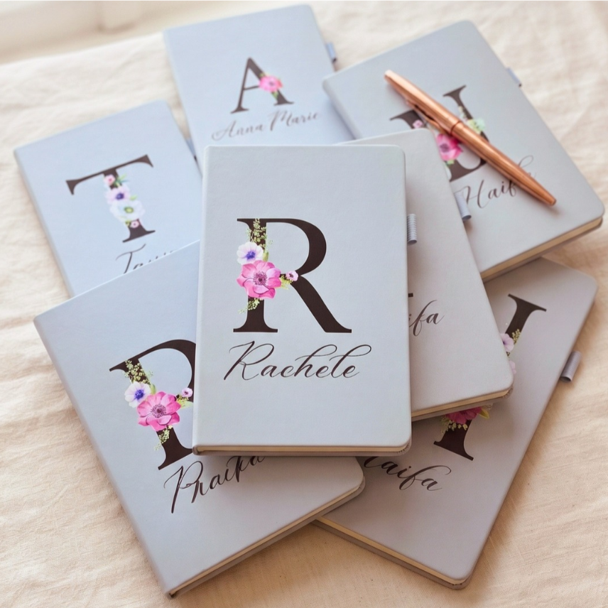 Custom light blue A5 notebook featuring a UV-printed floral initial and custom name on the cover.
