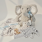 Gray plush elephant toy with a baby blanket and a teether on a light background